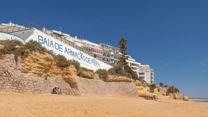A coastal hotel named "BANA DE ARMAÇÃO DE PÊRA" with a stone wall and beach in the foreground. - Apartment Meerlust with fantastic sea view and large balcony and garage (Armacao de Pera)