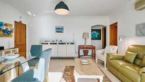 A living room with a sofa, a chair, a coffee table, a lamp, and a cabinet. - Apartment Meerlust with fantastic sea view and large balcony and garage (Armacao de Pera)