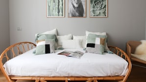 A bed with a white mattress and multiple pillows, a magazine on the bed, and three framed pictures on the wall above. - Cà Bèla - Vitruvio (Milan)