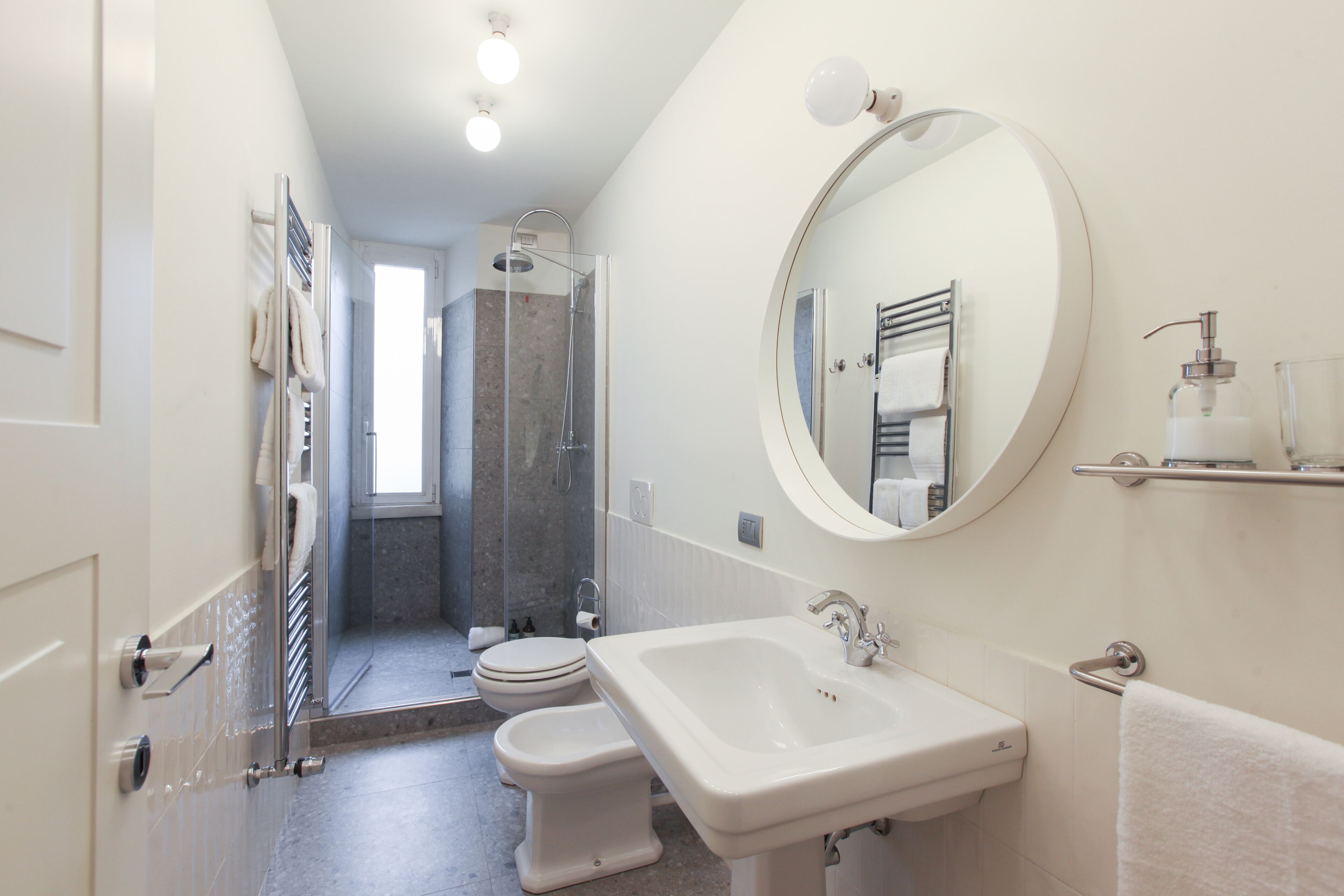 A modern bathroom with a shower, toilet, and sink.