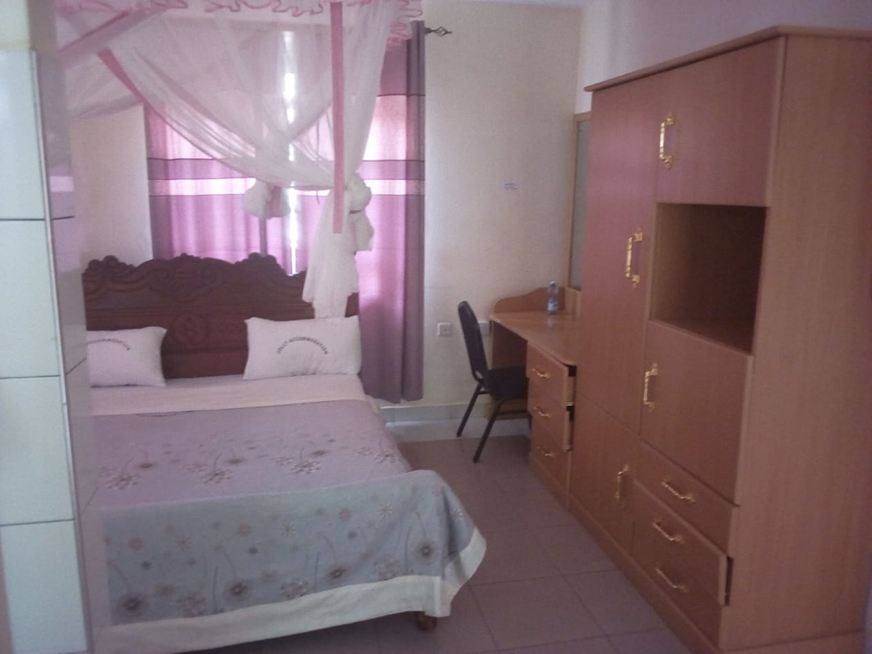 Une chambre à coucher avec un lit, un bureau et une armoire.