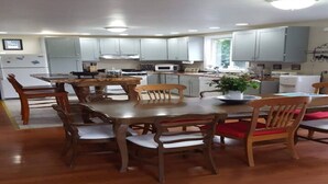 Une cuisine moderne avec une table et des chaises en bois, des meubles de couleur gris clair et un îlot central.