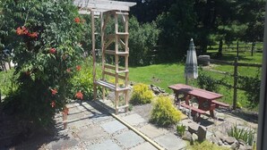 Un jardin agrémenté d’une pergola en bois, d’un chemin de pierres et d’une table de pique-nique.