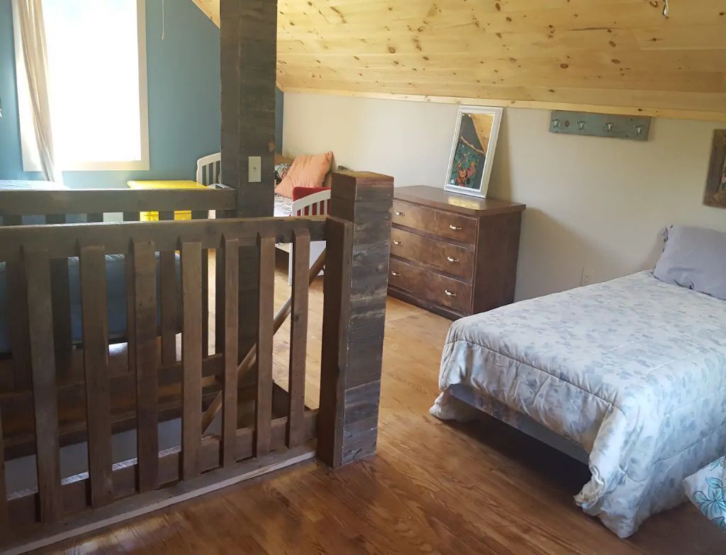 Ein Schlafzimmer mit einem hölzernen Bett, einem Schminktisch und einem Stuhl.