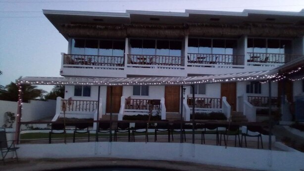 Um edifício de dois andares com varanda e piscina em primeiro plano.