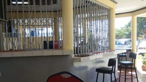 A restaurant with a bar area, chairs, and a tiled floor.