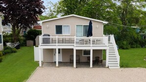 Une maison à deux étages dotée d’un porche et d’un escalier menant à l’étage supérieur.