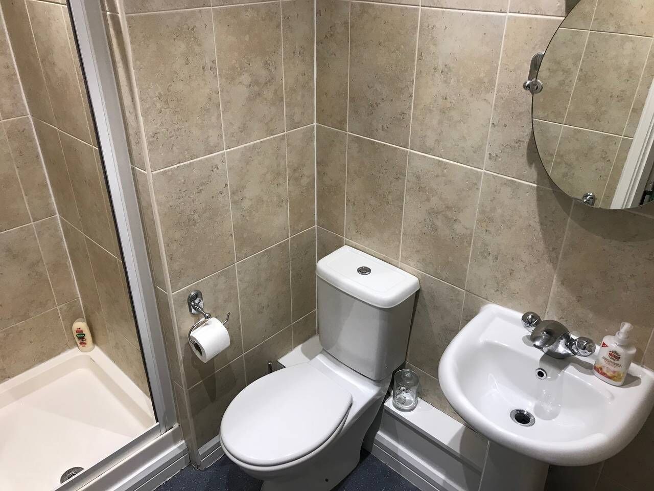 A bathroom with a toilet, sink, and shower.