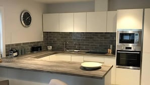Una cocina moderna con una isla central, un microondas integrado y un fregadero.