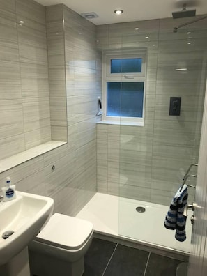 A modern bathroom with a shower, toilet, and sink. - Beautiful Refurbished Home - Short Walk to the Beach (Newquay)
