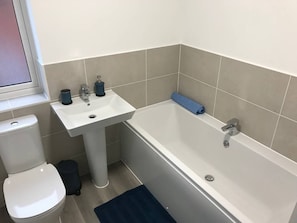 A bathroom with a toilet, sink, and bathtub.