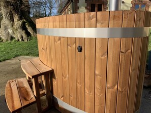 A wooden hot tub with a bench, surrounded by a wooden fence. - Abbey View Cottage - Scandi Spa Hot Tub (Chard)