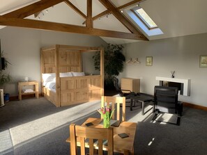 A room with a wooden four-poster bed, a desk with chairs, a fireplace, and a skylight. - Abbey View Cottage - Scandi Spa Hot Tub (Chard)