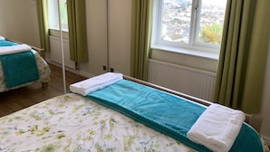 A bedroom with a bed, a window with a view, and a mirror. - Paignton View Holiday Home (Paignton)