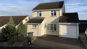A two-story residential house with a tiled roof, a garage, and a driveway. - Paignton View Holiday Home (Paignton)