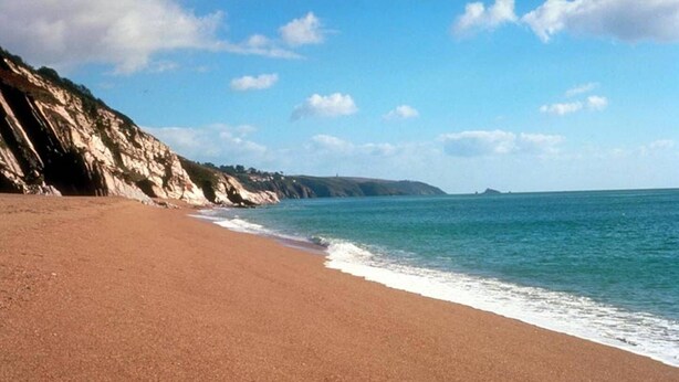 A beach with a clear sky, calm sea, and rocky cliffs. - Lakeview Cottage (Ivybridge)