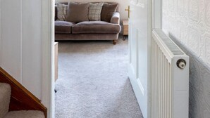 A hallway leading to a living room with a sofa and a framed picture on the wall. - Central Dartmouth Townhouse (Dartmouth)