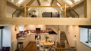 Eine Loft-Küche mit Essbereich, Holzbalken und Blick auf die obere Etage.