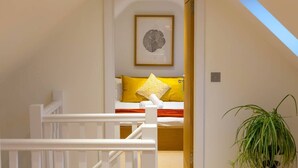 A bedroom with a bed, a framed picture on the wall, and a plant. - The Old Stable, Lower Parkstone, Poole (Poole)