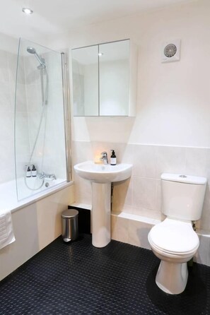 A bathroom with a glass-enclosed shower, a pedestal sink, and a toilet. - The Old Stable, Lower Parkstone, Poole (Poole)