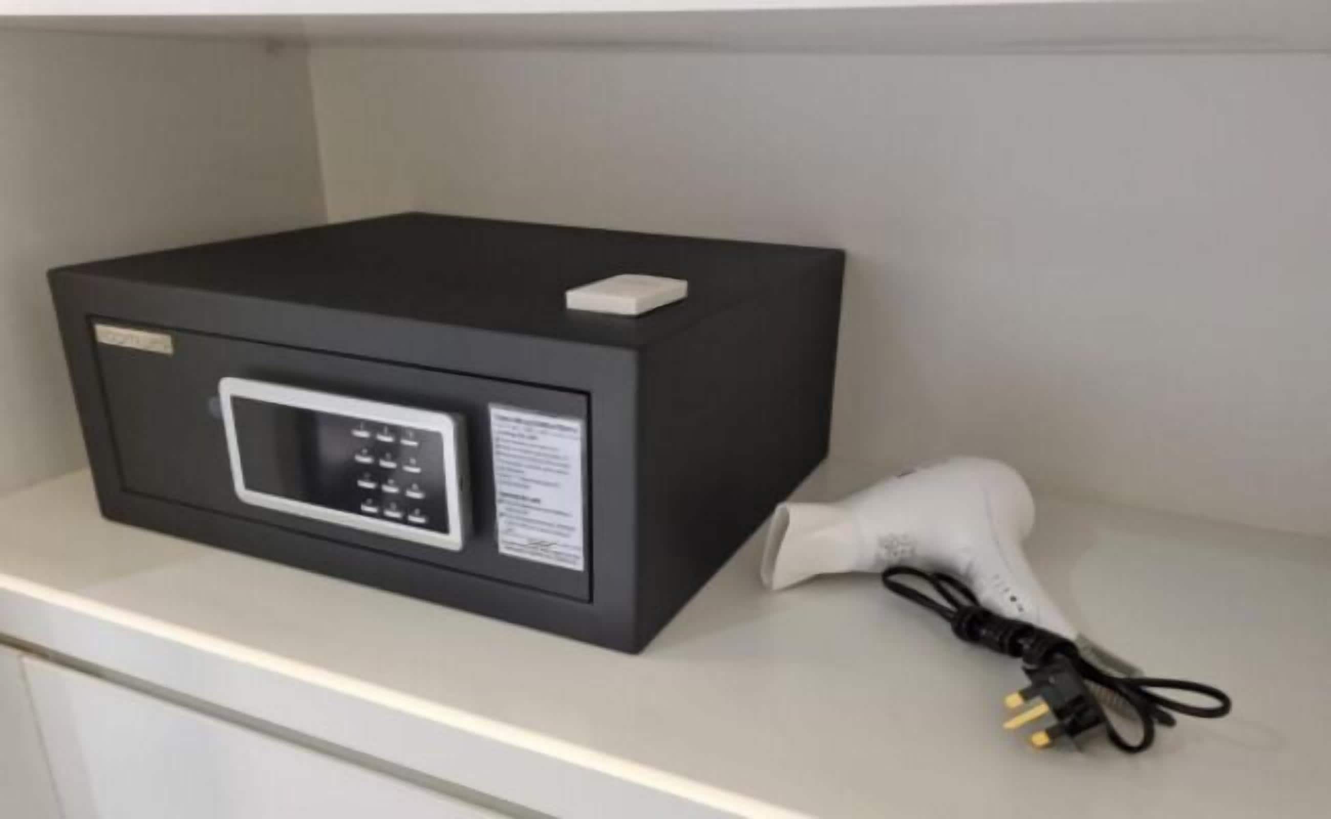 Un four à micro-ondes posé sur une étagère, avec un câble d’alimentation.
