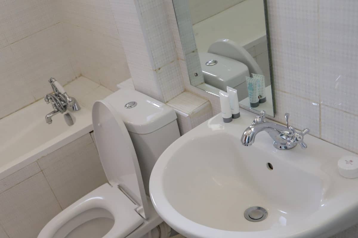 Un baño con inodoro, bidé y lavamanos.