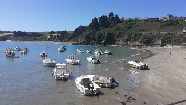 A coastal area with boats docked near the shore and a sandy beach.