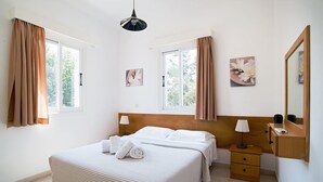 Een hotelkamer met een groot bed, twee nachtkastjes, een spiegel en kunst aan de muur.