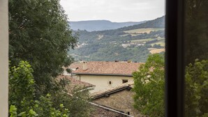 Vista de un paisaje rural con un edificio de piedra y techo de tejas.