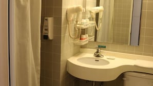 A bathroom with a sink, a mirror, a toilet, and a hairdryer. - Jinjiang Inn(Beijing Tongzhou Beiyuan Subway Station) (Tongzhou)