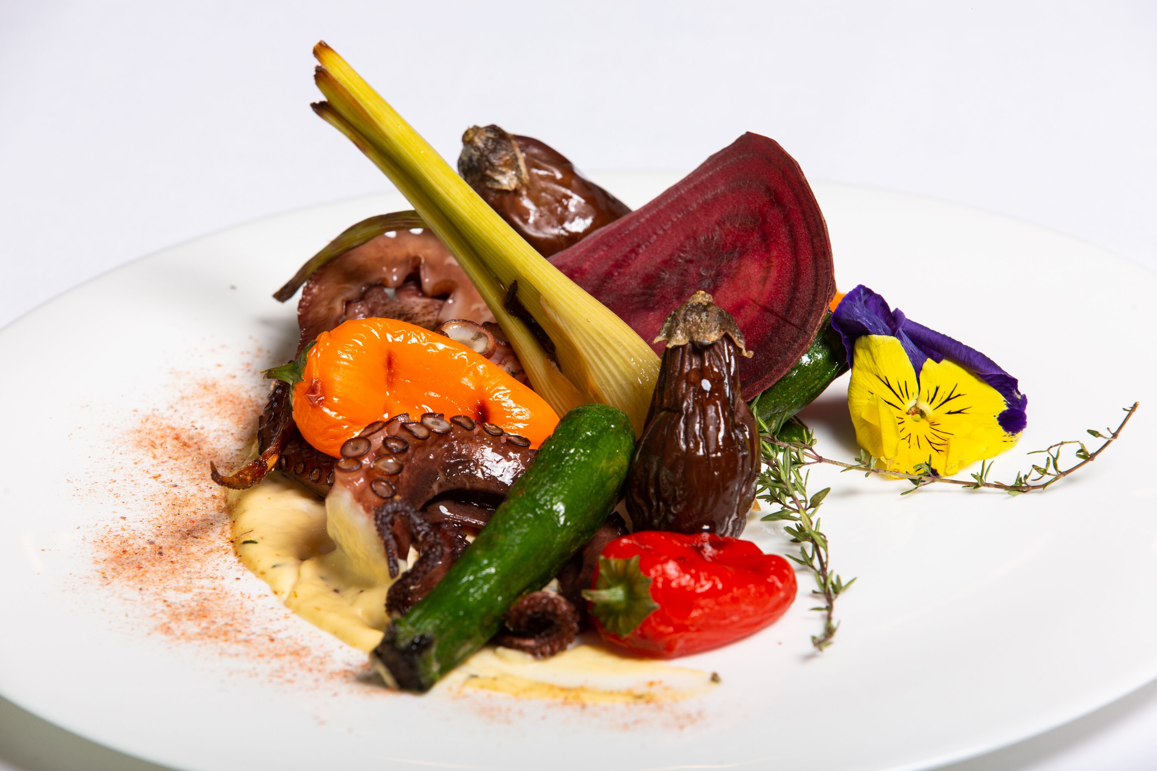 Un plato de comida con varios vegetales y un trozo de carne.