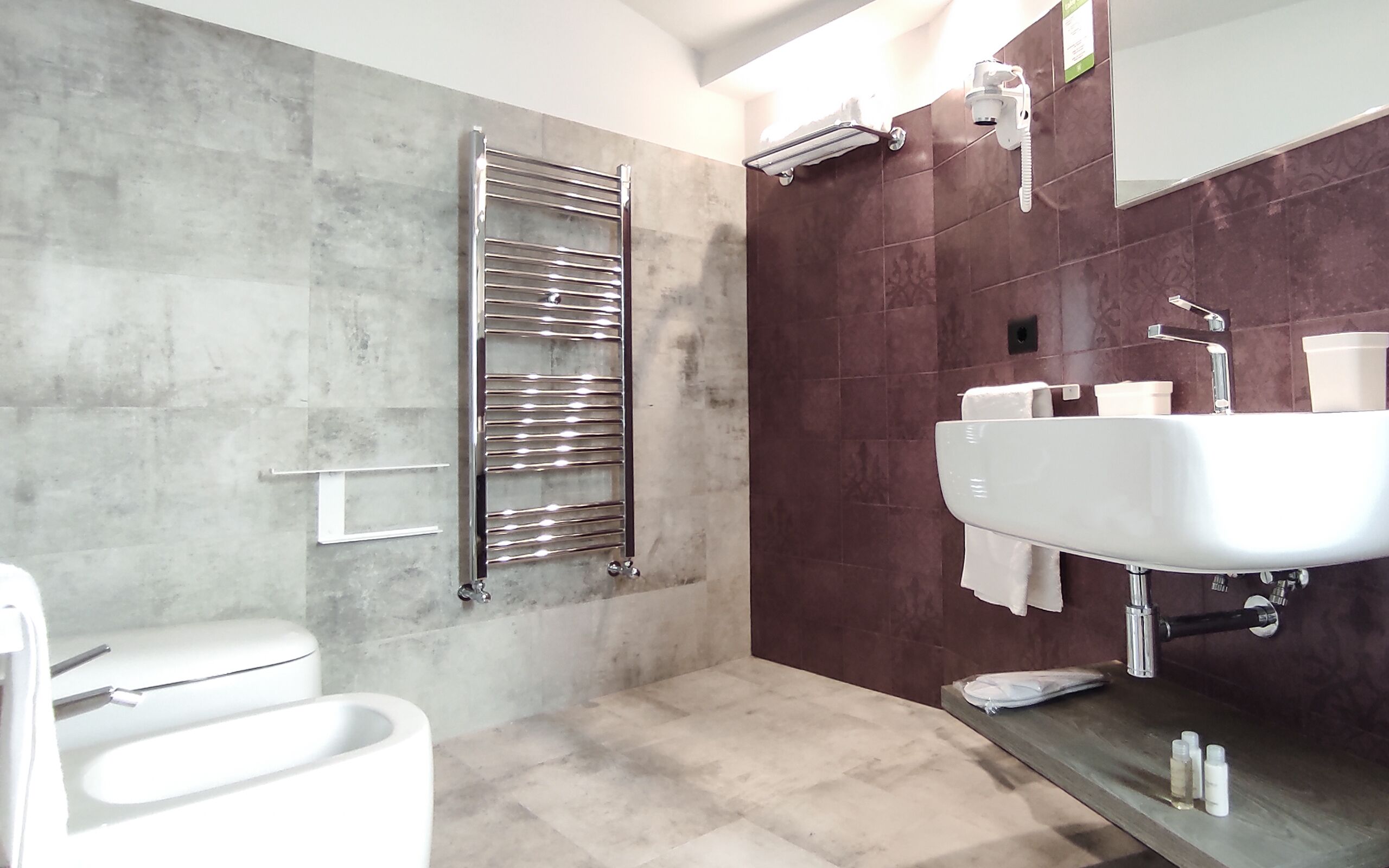 Un baño moderno con inodoro, ducha con puerta de cristal y lavamanos con espejo.