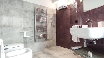 Un baño moderno con inodoro, ducha con puerta de cristal y lavamanos con espejo.