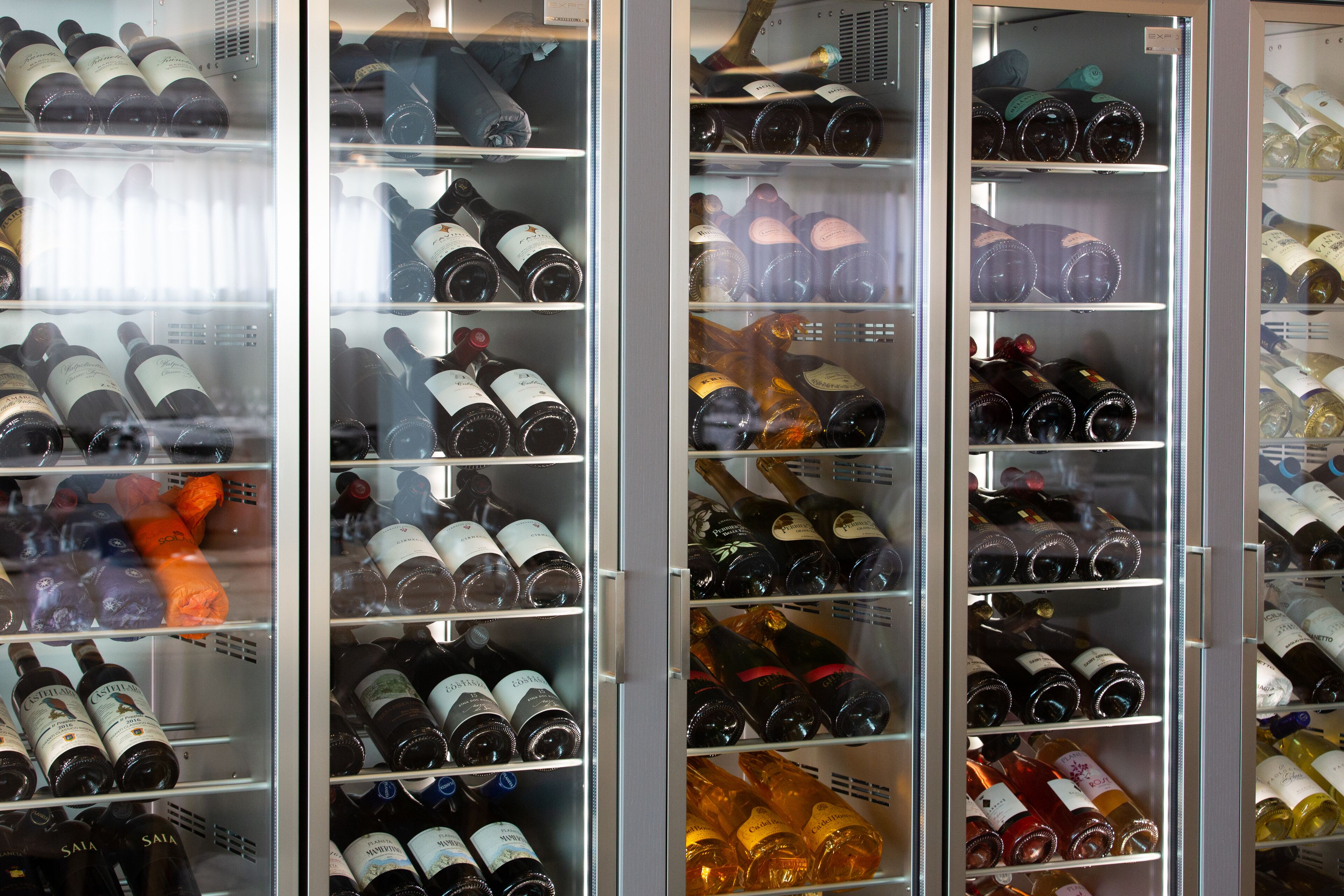 A wine refrigerator stocked with various bottles of wine.