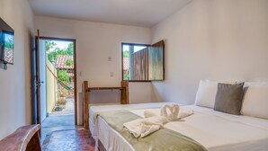 A bedroom with a bed, a bench, a window, and a view of a courtyard. - Pousada Trilha do Mar (Marechal Deodoro)