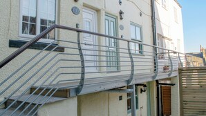 Un bâtiment doté d’un escalier métallique menant à un palier où se trouve une porte portant l’inscription « 3 ».
