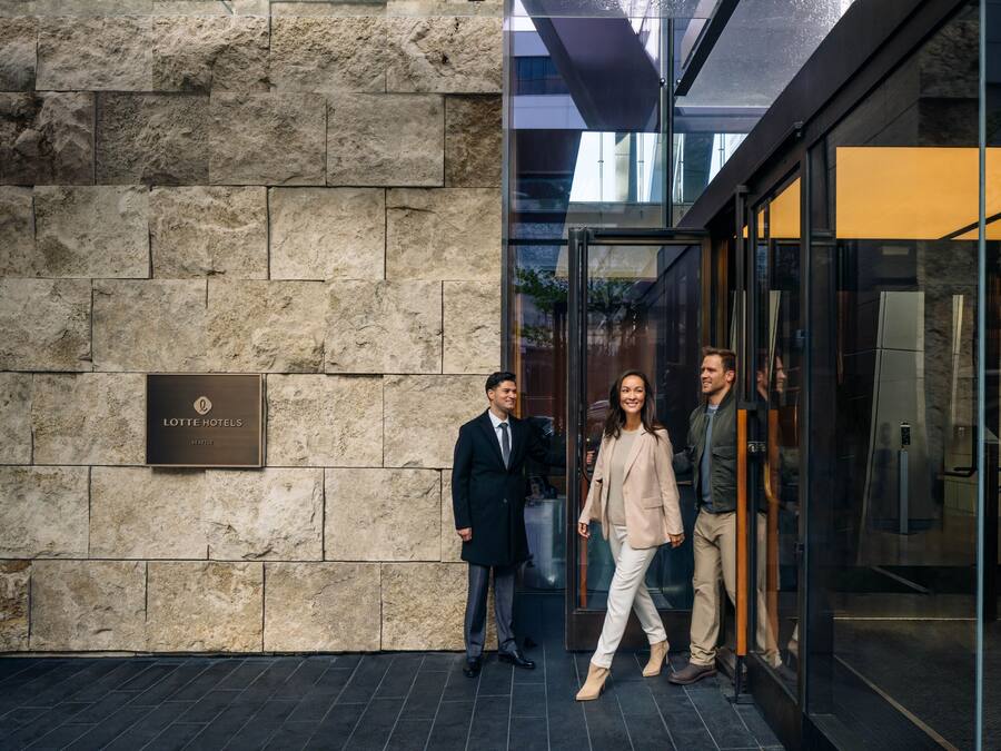 A stone facade with a plaque reading "LOTTE HOTELS" and a glass entrance.