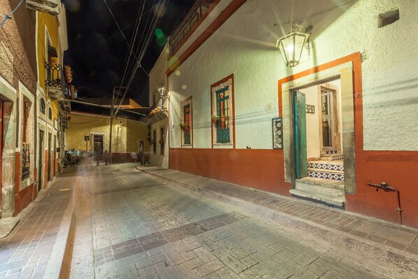 A narrow street with buildings on either side, featuring a mix of traditional and modern architectural styles.