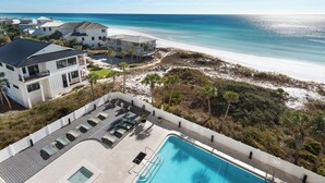 A beachfront property with a swimming pool, multiple houses, and a sandy beach. - Beach Front, Balcony, Free Beach Chair Service, Tennis Pros (Miramar Beach)