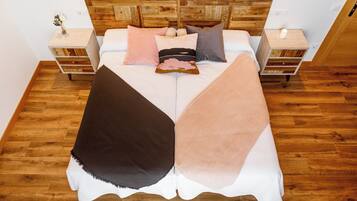 Un lit avec une tête de lit en bois, deux tables de chevet et un plancher en bois.
