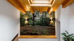 A room with a skylight, wooden beams, and a forest view. - Posada Rural Fuente Juliana (Ruente)