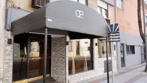 A building with a covered entrance, large windows, and a stone facade. - Once Plaza Hotel (Buenos Aires)