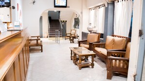 A spacious living area with wooden furniture, a staircase, and a view of the outside. - Once Plaza Hotel (Buenos Aires)