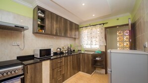 Una cocina moderna con armarios de madera, microondas, estufa y refrigerador.