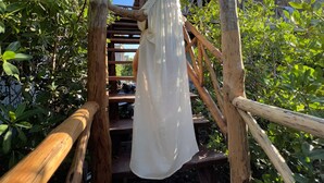 Uma escada de madeira com uma pessoa de vestido branco.