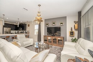 Uma sala de estar moderna com sofá, mesa de centro e televisão.