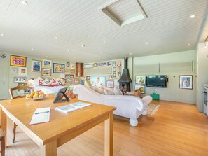 Un salon chaleureux avec une table en bois, un canapé, une cheminée et un téléviseur.