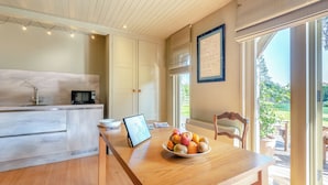 Una cocina moderna con una mesa de madera, un bol de fruta y un cuadro enmarcado.