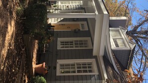 A two-story house with a porch, multiple windows, and a visible chimney. - Exclusive Myers Park RNC Rental 4000 sq ft Home - RENOVATED 15 min. to downtown (Charlotte)
