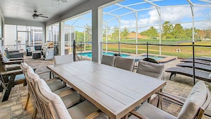 En overdækket udendørs terrasse med pool, siddepladser og grillområde.